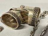 a silver bracelet with a chain around it and a pair of scissors