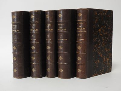 three old books sitting on top of each other on a white surface