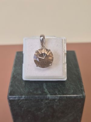 silver plated pendant with a faceted stone in the middle of it