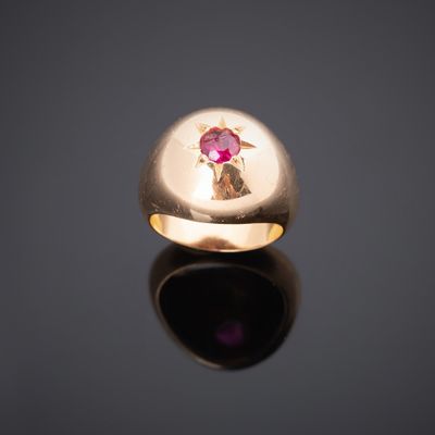 un gros plan d'une bague en or ornée d'un rubis au centre