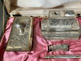 a silver box with a set of silver items in it