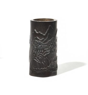 a black vase with a design on it on a white surface