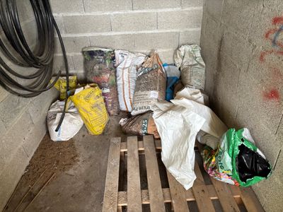 un tas d'ordures posé sur une palette près d'un mur