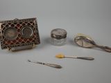 a silver box, spoons, and other items on a table