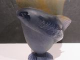 un vase en verre orné d'un oiseau, posé sur une table