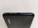 the back of a black cell phone sitting on top of a white table