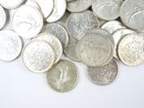 a pile of silver and silver coins on a white surface