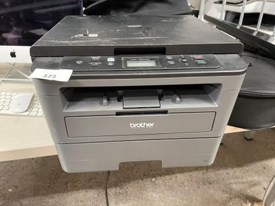 une imprimante posée sur un bureau à côté d'un ordinateur
