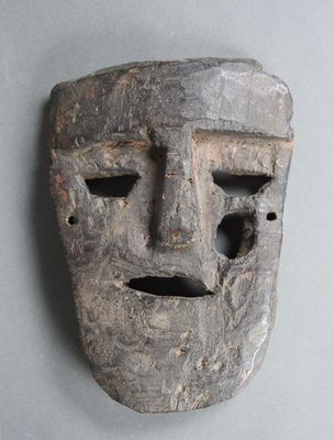 un masque en bois percé d'un trou au milieu