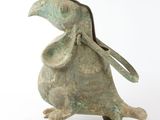 bronze figurine of a bird with a bag on its back