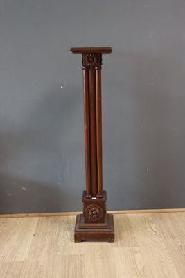 a tall wooden pedestal with a clock on top of it