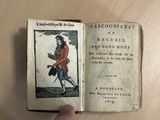 someone is holding a book with a picture of a man in a red coat