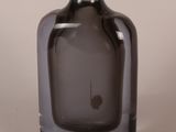 a gray glass bottle with a black handle sitting on a table