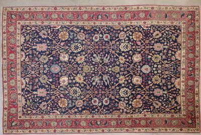 un tapis persan ancien à fond bleu et bordure rouge
