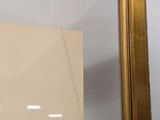 an image of a gold framed mirror hanging on a wall