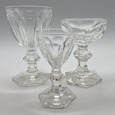 trois verres à pied en verre transparent posés les uns à côté des autres sur une table