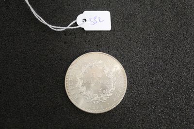 a silver coin with a price tag on a black surface