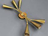 a close up of a brass wall light with five brass cones