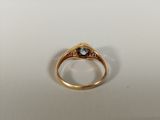 a close up of a gold ring with a blue topaz stone