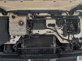 a white truck with its hood open and a radiator in the back of it