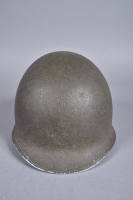 un vieux casque est posé sur une surface blanche