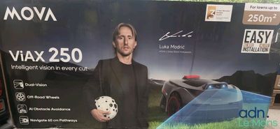 un homme tenant un ballon de foot devant une boîte