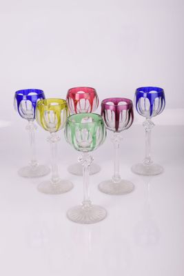 six verres à vin alignés sur une surface blanche