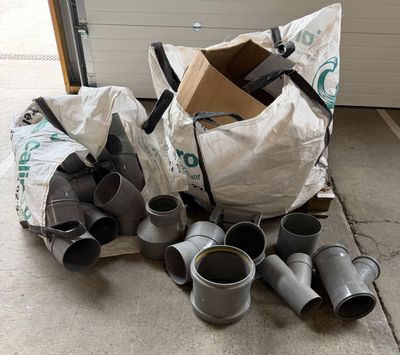 a pile of duct fittings on the ground next to a garage door