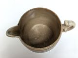 a brown cup with a handle on a white surface