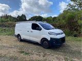 La camionnette est garée sur l'herbe, dans le champ.