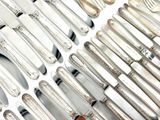 a lot of silver spoons and knives on the table
