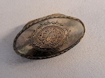 a silver plate with a picture of a coat of arms on it