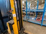 a forklift in a warehouse with lots of pallets