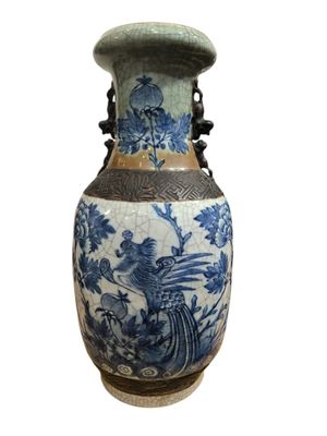 a blue and white vase with a bird and flowers on it