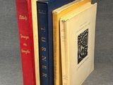 three books are stacked on top of each other on a gray surface
