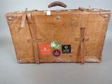 a brown suitcase with stickers on it sitting on a table