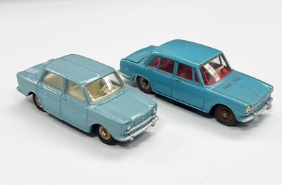 deux voitures jouets assises l'une à côté de l'autre sur une surface blanche