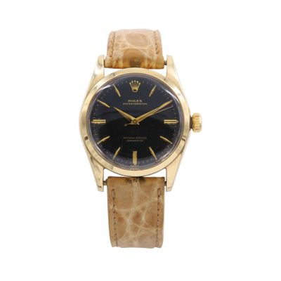 gros plan d'une montre sur fond blanc avec un bracelet marron