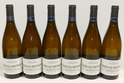 six bouteilles de vin sont alignées sur une surface blanche