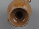a brown vase sitting on a table with a gray background