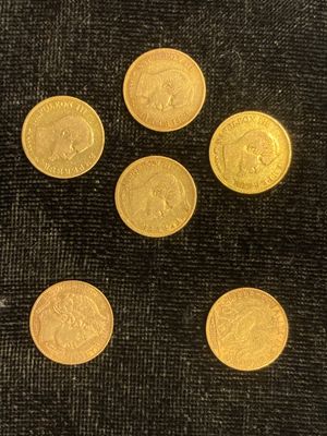 six pièces d'or sont disposées en cercle sur un tissu noir