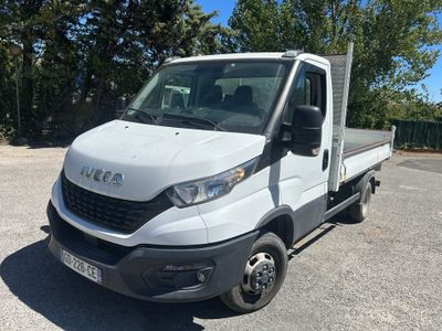 un camion blanc garé sur un parking, avec des arbres en arrière-plan