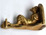 a gold statue of a woman laying on a bed
