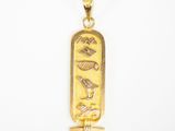 gros plan d'un pendentif en or sur fond blanc