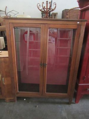 a cabinet with a glass door and a candle holder on top of it
