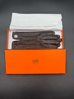 three pairs of black leather gloves in a box on a table