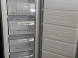 a white refrigerator with its door open next to another white refrigerator