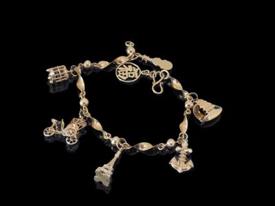 un gros plan d'un bracelet orné de breloques sur fond noir