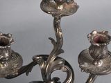 a silver candelab with three candles on it