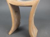 une image représentant un petit tabouret en bois posé sur une surface grise